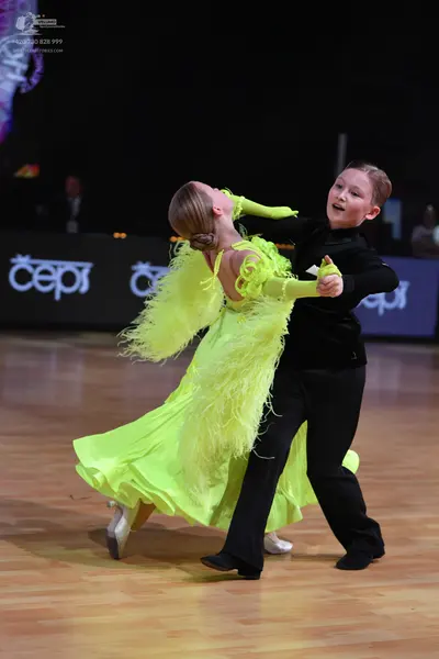 Dancesport competitor: Female dancer: bright lime green ballroom gown with long flowing fringe