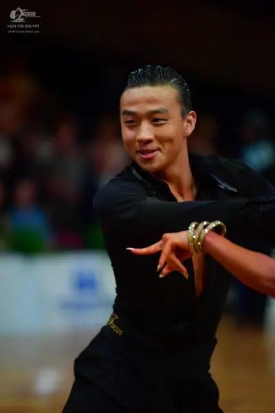 Dancesport competitor: Male dancer: black long-sleeved dance top and trousers with gold "Focus" letteri