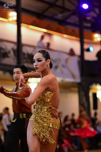 Dancesport competitor: Female dancer: gold sequin Latin dress