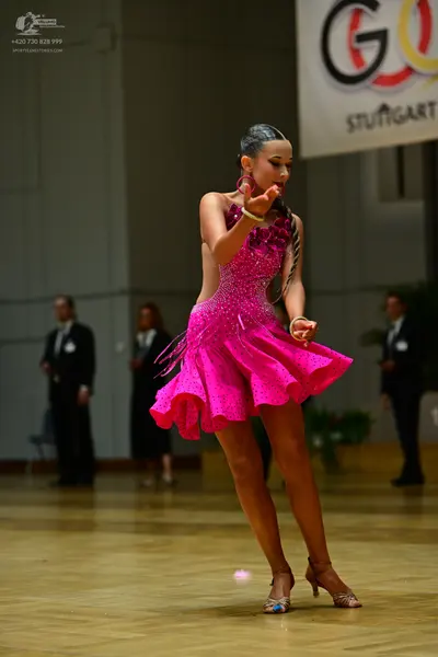 Dancesport competitor: Female dancer: bright pink latin dress with sequins and fringe
