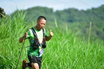 Marathon runner: Runner 1: green short-sleeved shirt, black shorts, black hydration vest, and tre