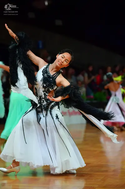 Dancesport competitor: Female dancer: White ballroom dress with black lace and sequin embellishments on