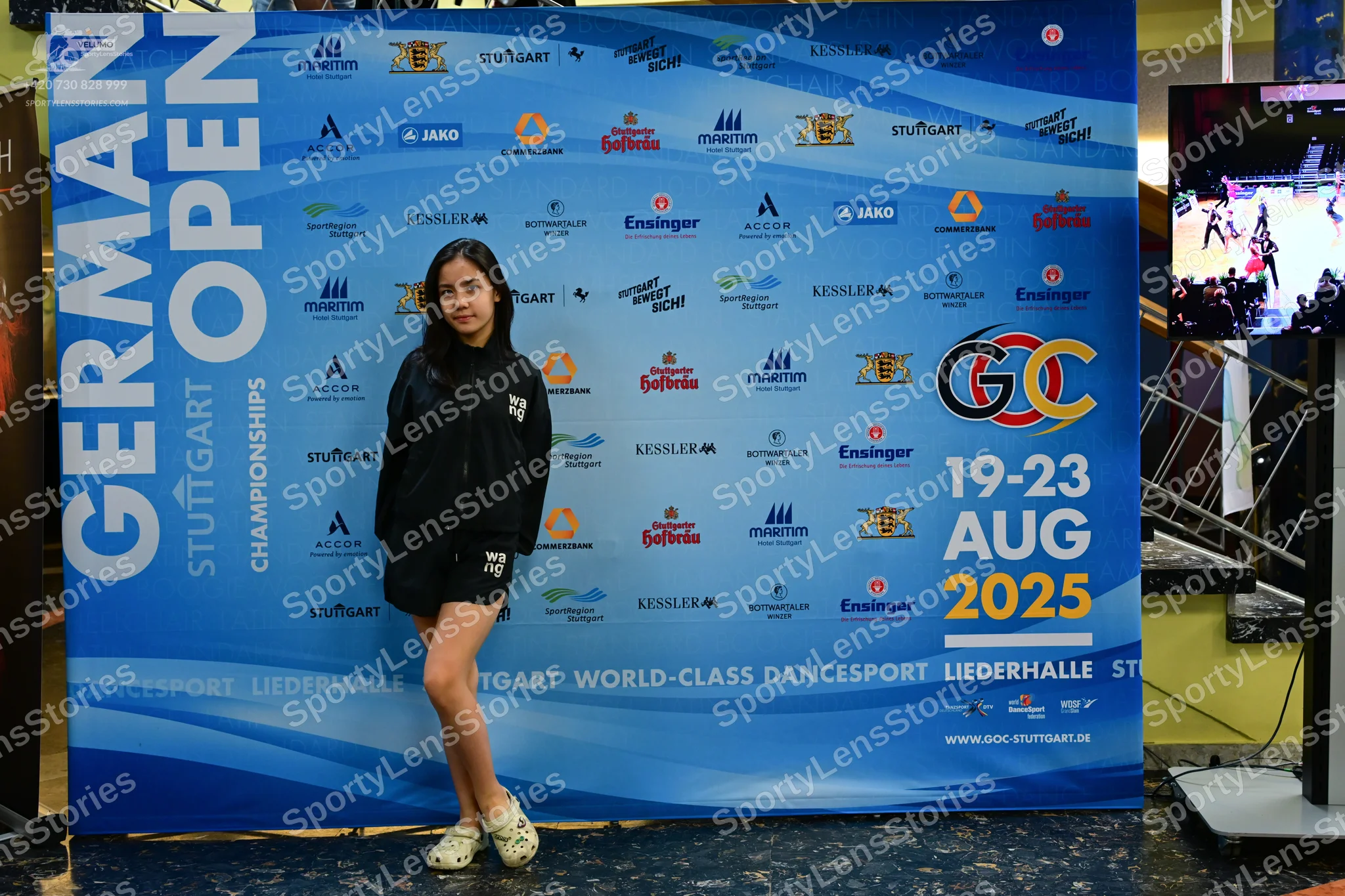 Dancesport competitor: Female dancer: black zip-up jacket and black shorts