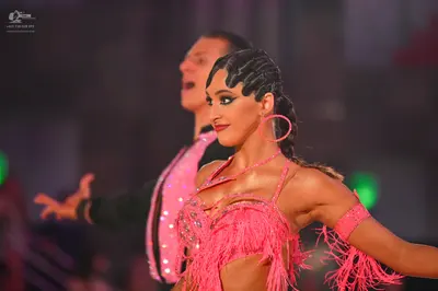 Dancesport competitor: Male dancer: black suit with a pink sequin stripe