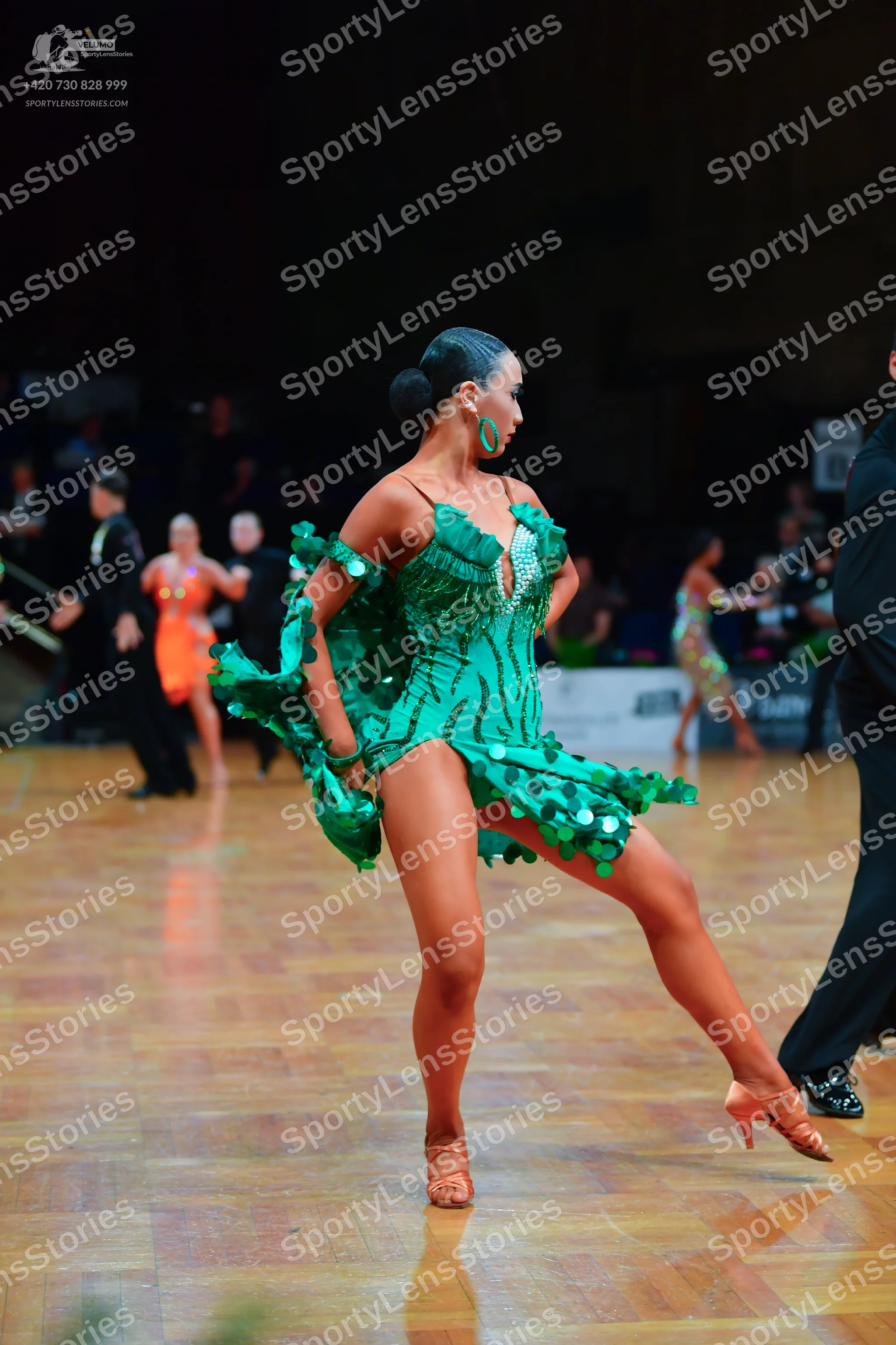 Dancesport competitor: Main female dancer: green latin dress with sequins and fringe