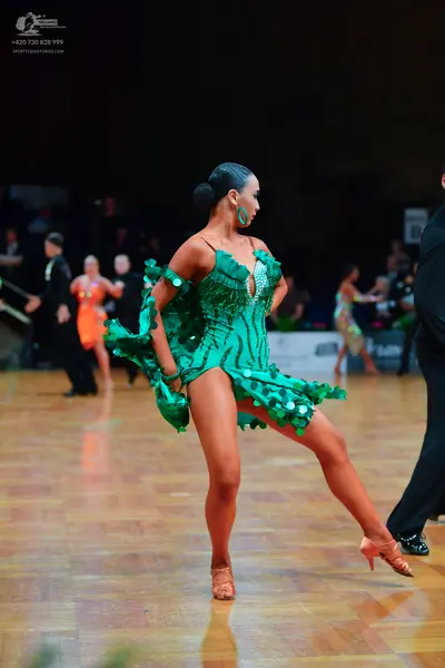 Dancesport competitor: Main female dancer: green latin dress with sequins and fringe