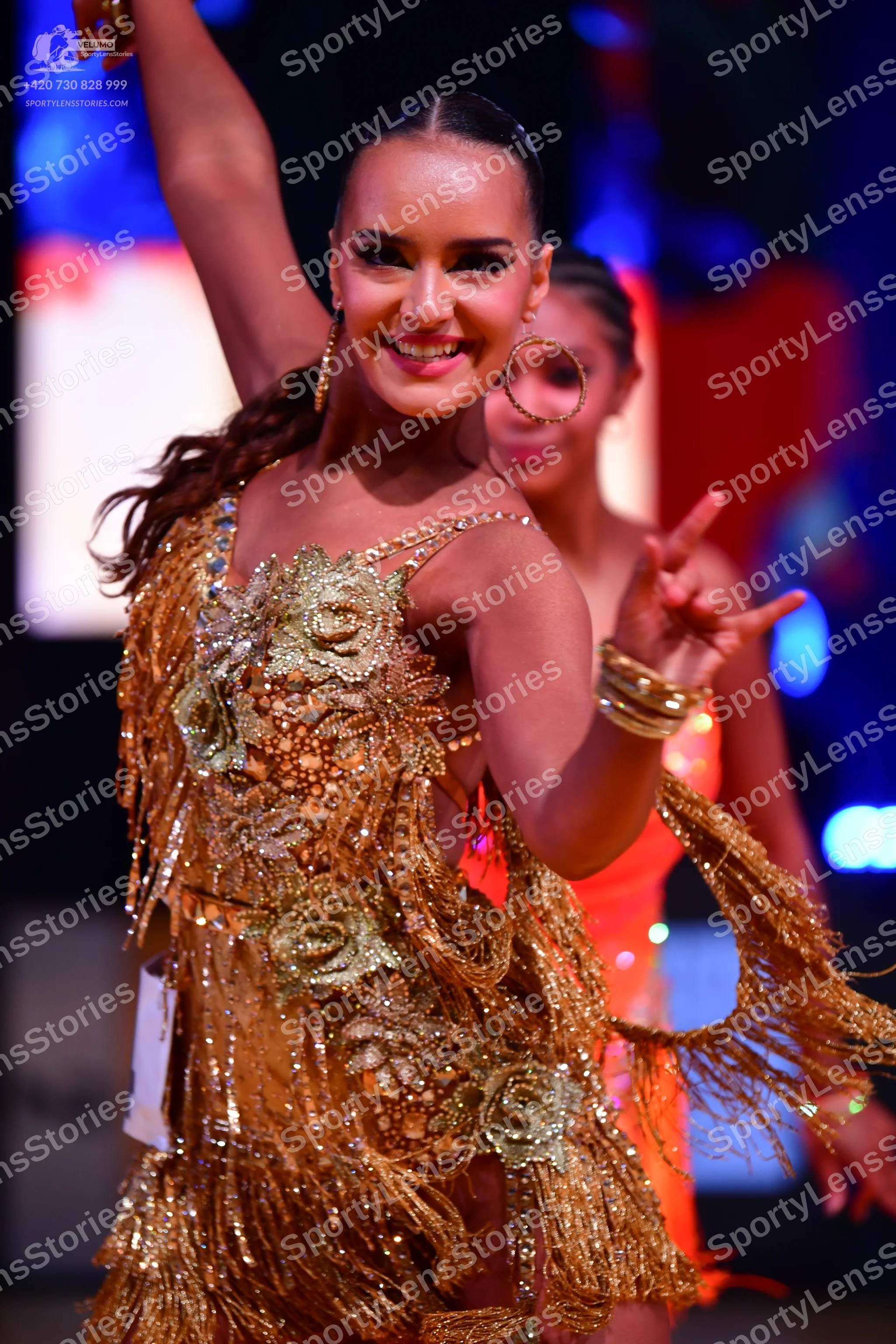 Dancesport competitor: Female dancer 1: gold Latin dress with sequin floral patterns and long gold frin