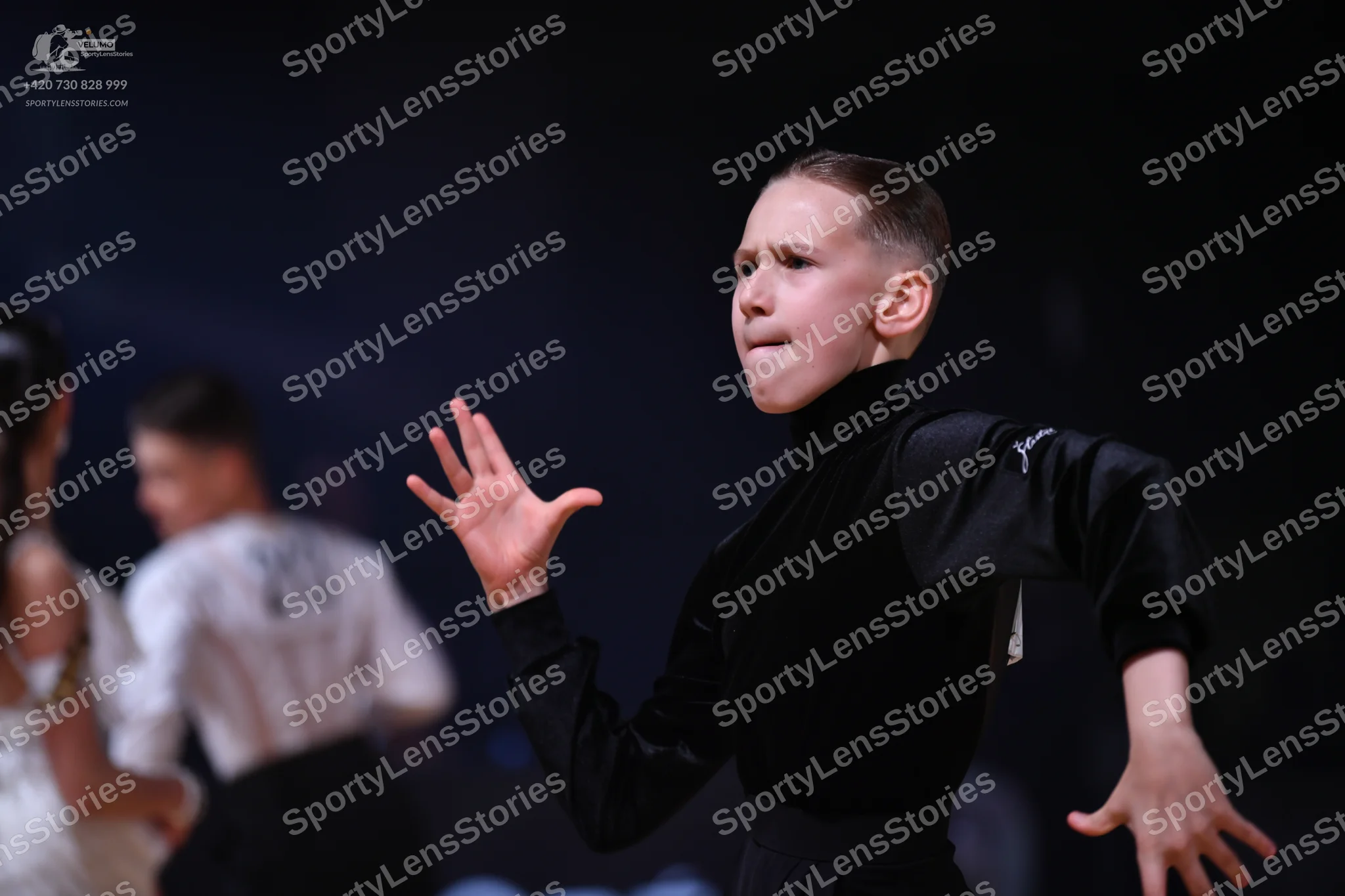 Dancesport competitor: Foreground male dancer: black long-sleeved mock neck top