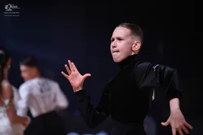 Dancesport competitor: Foreground male dancer: black long-sleeved mock neck top