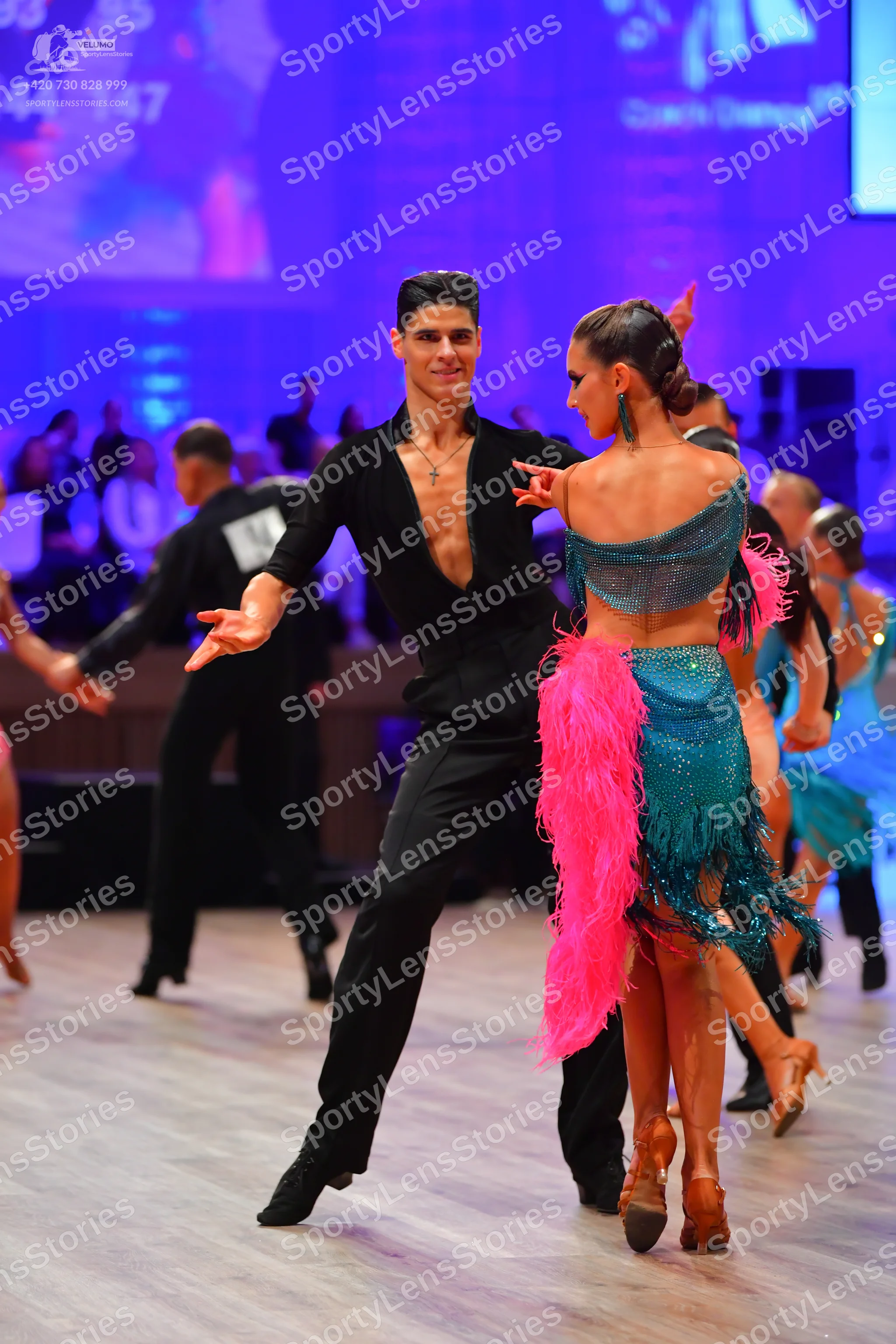 Dancesport competitor: Male dancer: black long-sleeved top with a deep V-neck and black trousers
