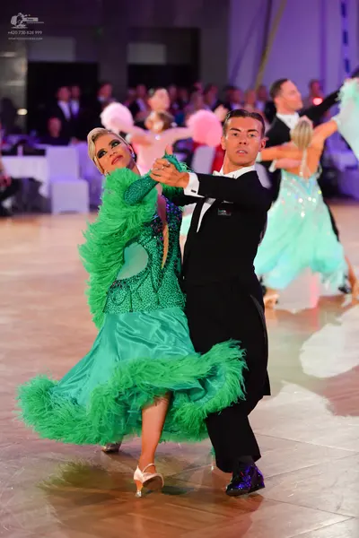 Dancesport competitor: Main female dancer: teal latin dress with large green feather fringe and sequin-