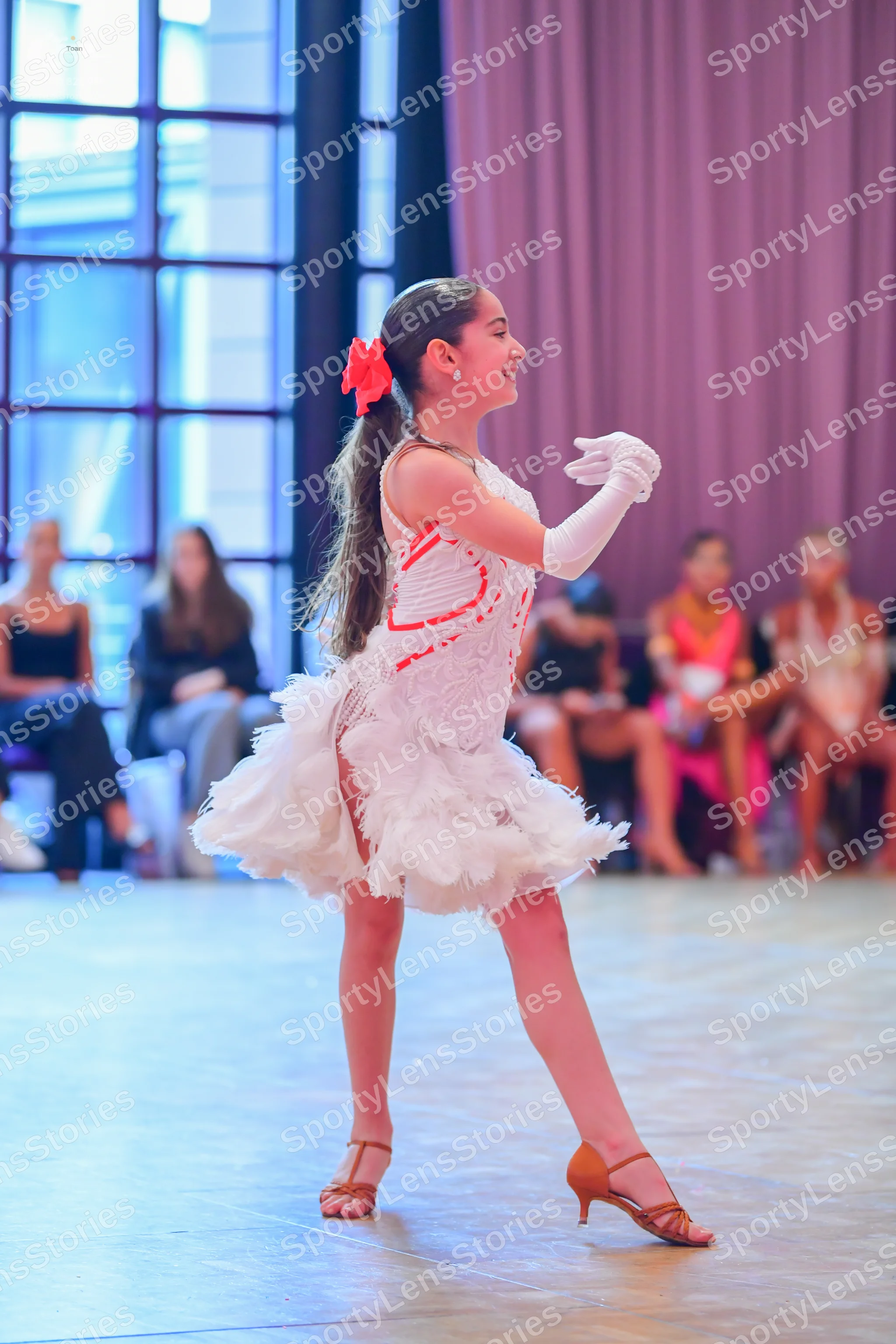 Dancesport competitor: Main dancer: White Latin dance dress with a textured, ruffled skirt and red patt