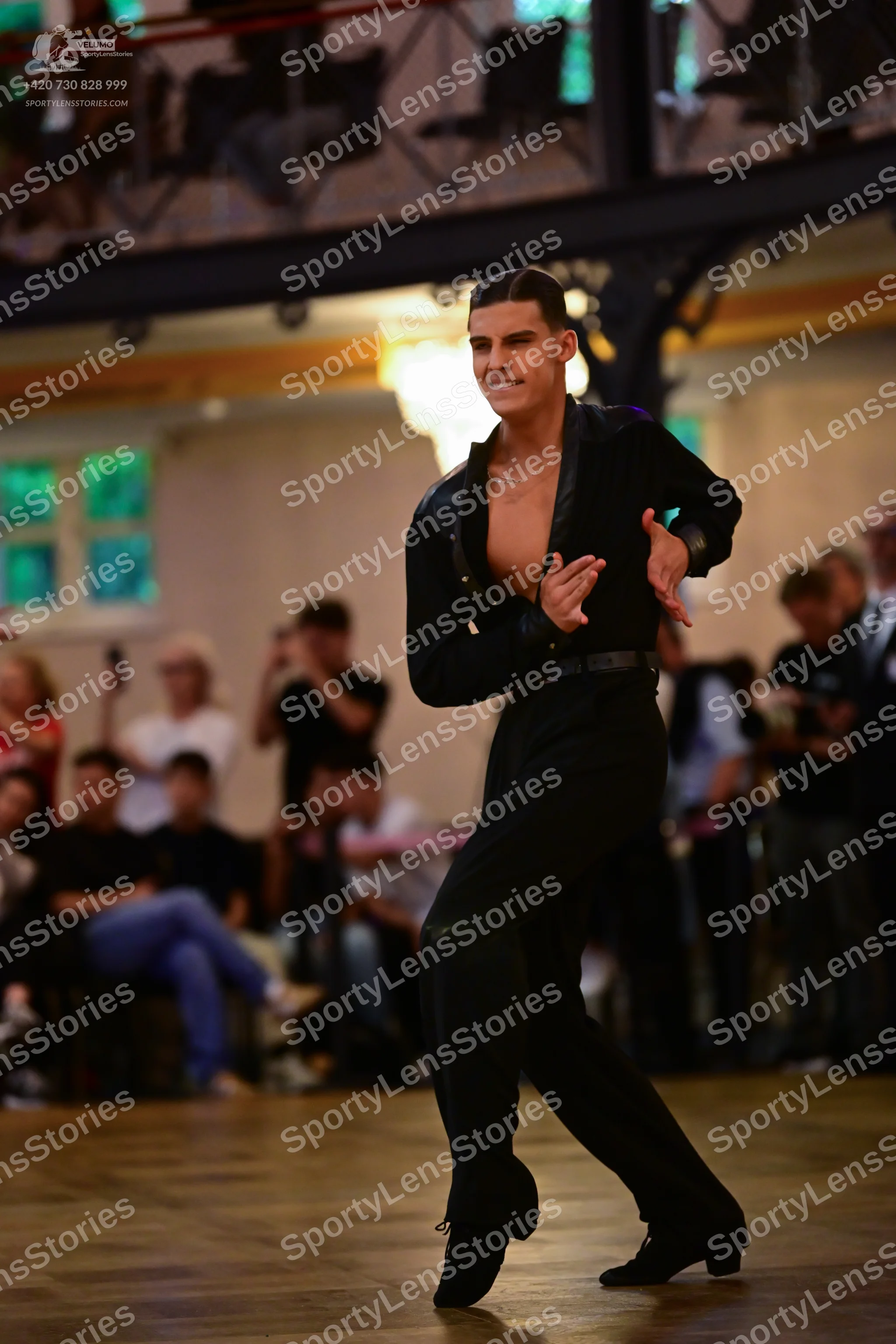 Dancesport competitor: Male dancer: black Latin-style shirt with satin-like lapels and black trousers