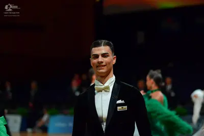 Dancesport competitor: Male dancer: black suit with satin lapels, white shirt, and white bow tie