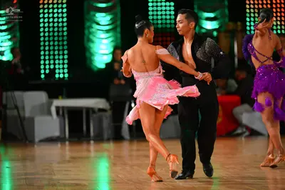 Dancesport competitor: Female dancer in center: light pink/lavender Latin dress with sequins and fringe