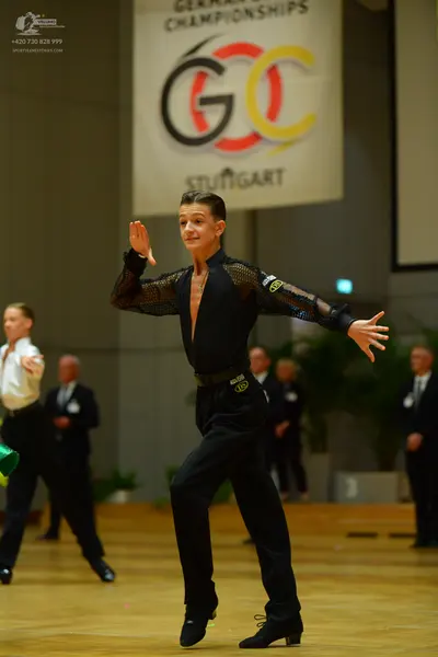 Dancesport competitor: Main dancer: black long-sleeved shirt with sheer/mesh sleeves and chest, black t