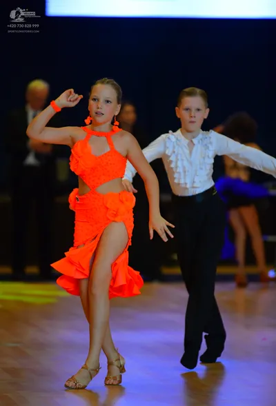 Dancesport competitor: Female dancer: bright orange latin dress with a halter neck, cutout waist, and a