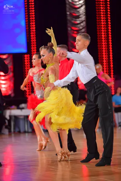 Dancesport competitor: Main female dancer: yellow feathered/fringed Latin dress with a nude-colored, em