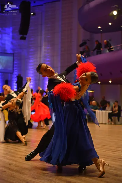 Dancesport competitor: Foreground male dancer: black suit and white shirt