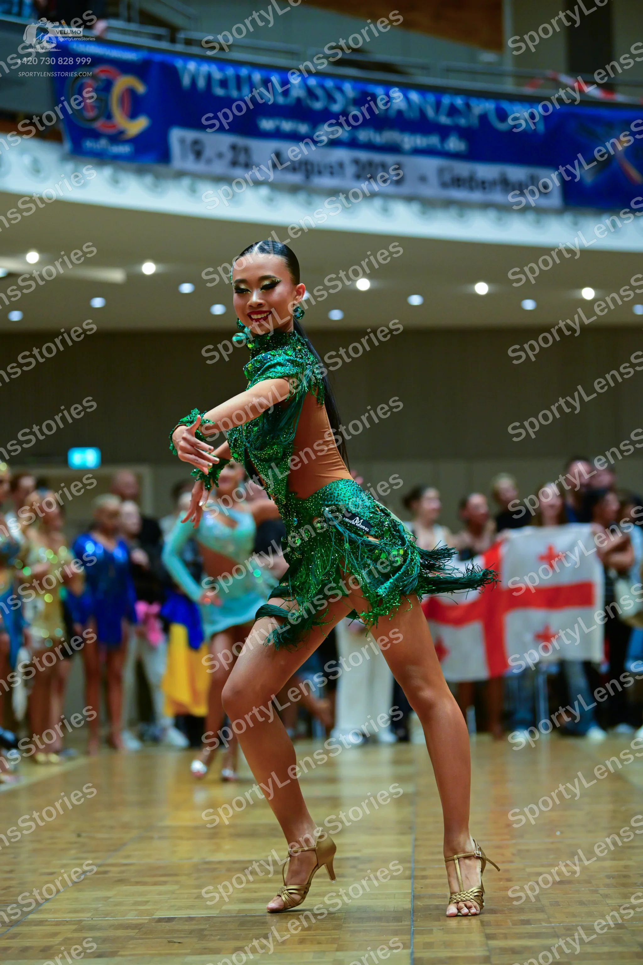 Dancesport competitor: Female dancer: green latin dress with sequins and sheer mesh panels