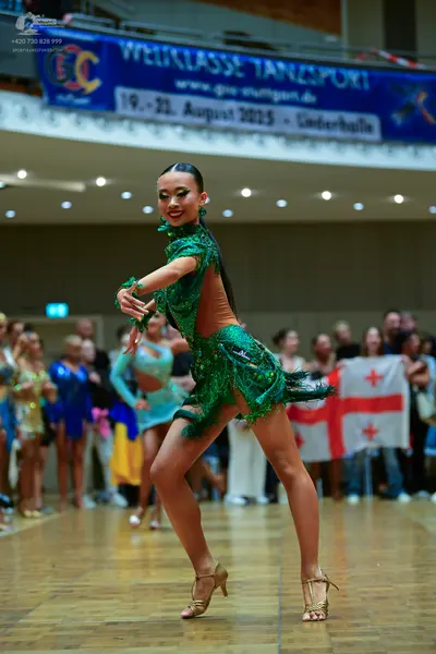 Dancesport competitor: Female dancer: green latin dress with sequins and sheer mesh panels