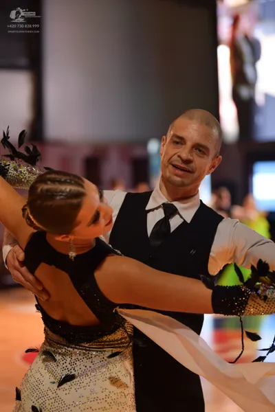 Dancesport competitor: Male dancer: black waistcoat over a white long-sleeved shirt with a black neckti