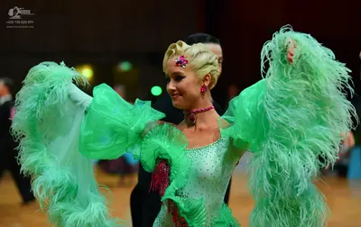 Dancesport competitor: Female dancer: light green Latin dance dress with large, voluminous feathery sle