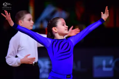 Dancesport competitor: Male dancer: white long-sleeved shirt and black trousers with a black belt