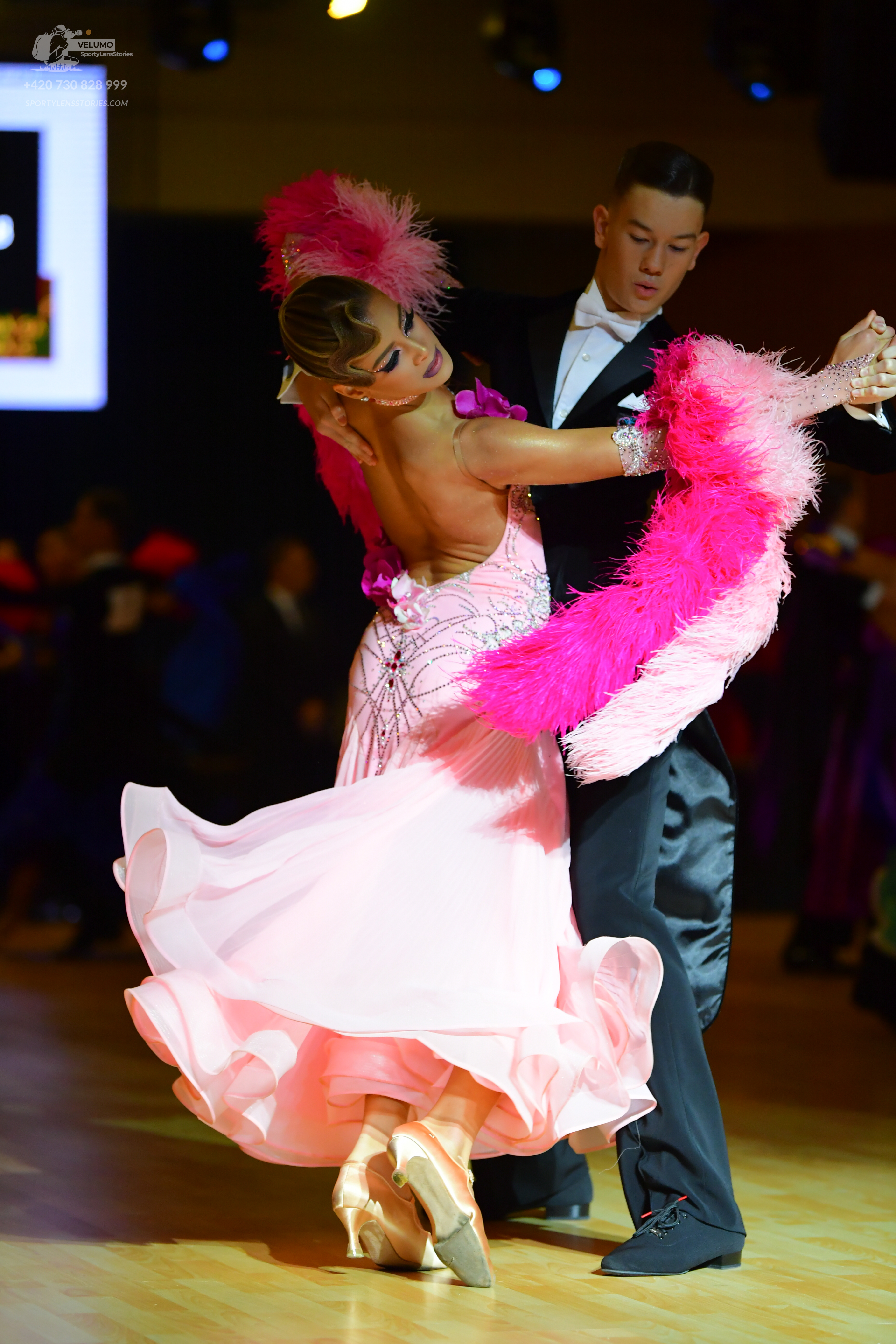 Dancesport competitor: Male dancer: black formal suit with a white shirt, white bow tie, and white pock