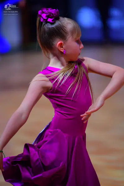 Dancesport competitor: Female dancer: magenta satin latin dress with a voluminous skirt and a matching 