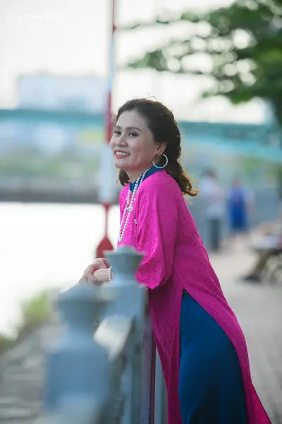 Dancesport competitor: Female dancer: long fuchsia pink patterned tunic with a side slit, a dark blue l
