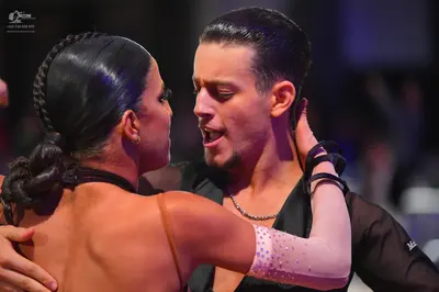 Dancesport competitor: Male dancer: black shirt with a slight sheen, wearing a silver chain necklace