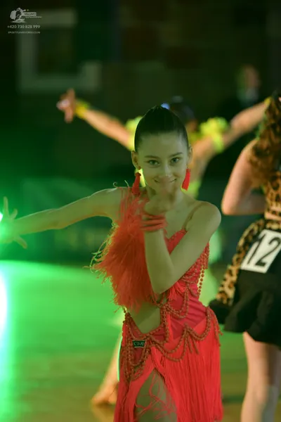 Dancesport competitor #12: Female dancer (foreground): pink Latin dress with long fringe and bead/sequin em