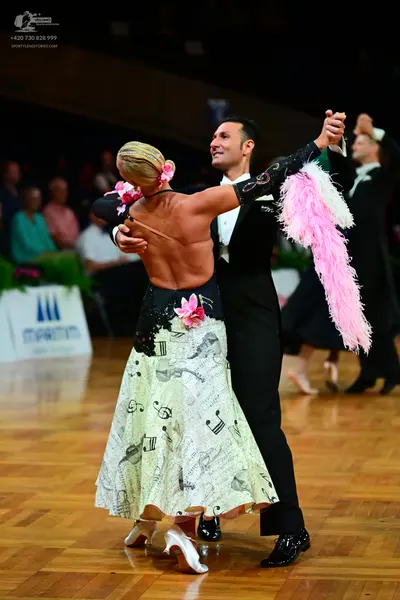 Dancesport competitor: Female dancer: long ballroom dress with a cream-colored skirt featuring a black 