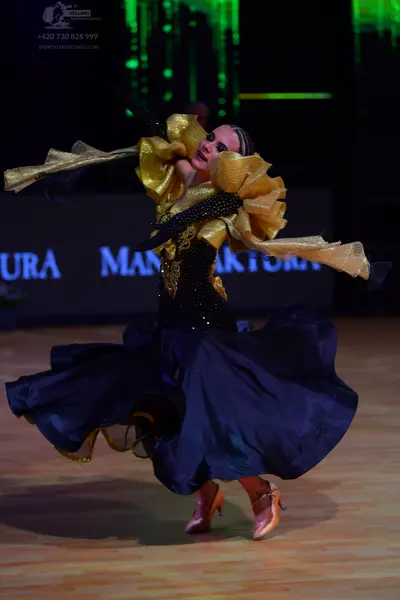 Dancesport competitor: Female dancer: navy blue ballroom gown with a black bodice featuring gold sequin
