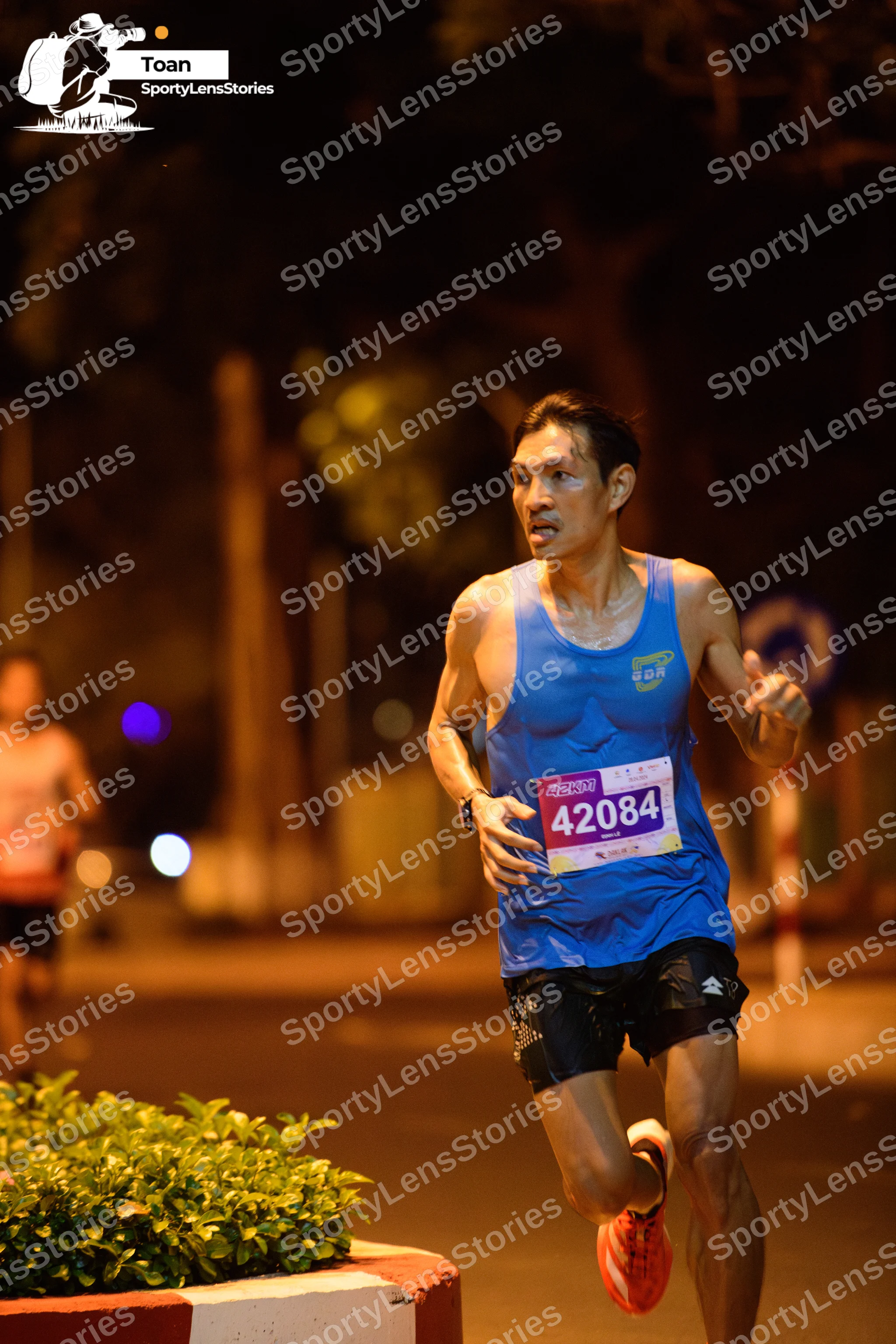 Marathon runner #42084: Runner 1: blue tank top, black shorts, orange shoes