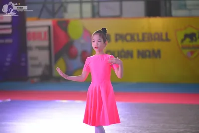 Dancesport competitor: Female**

*   **Color:** Bright Pink
*   **Fabric:** Shiny, likely satin or a si