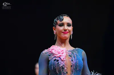 Dancesport competitor: Female dancer: blue and silver shimmering dress with a large pink fabric flower 