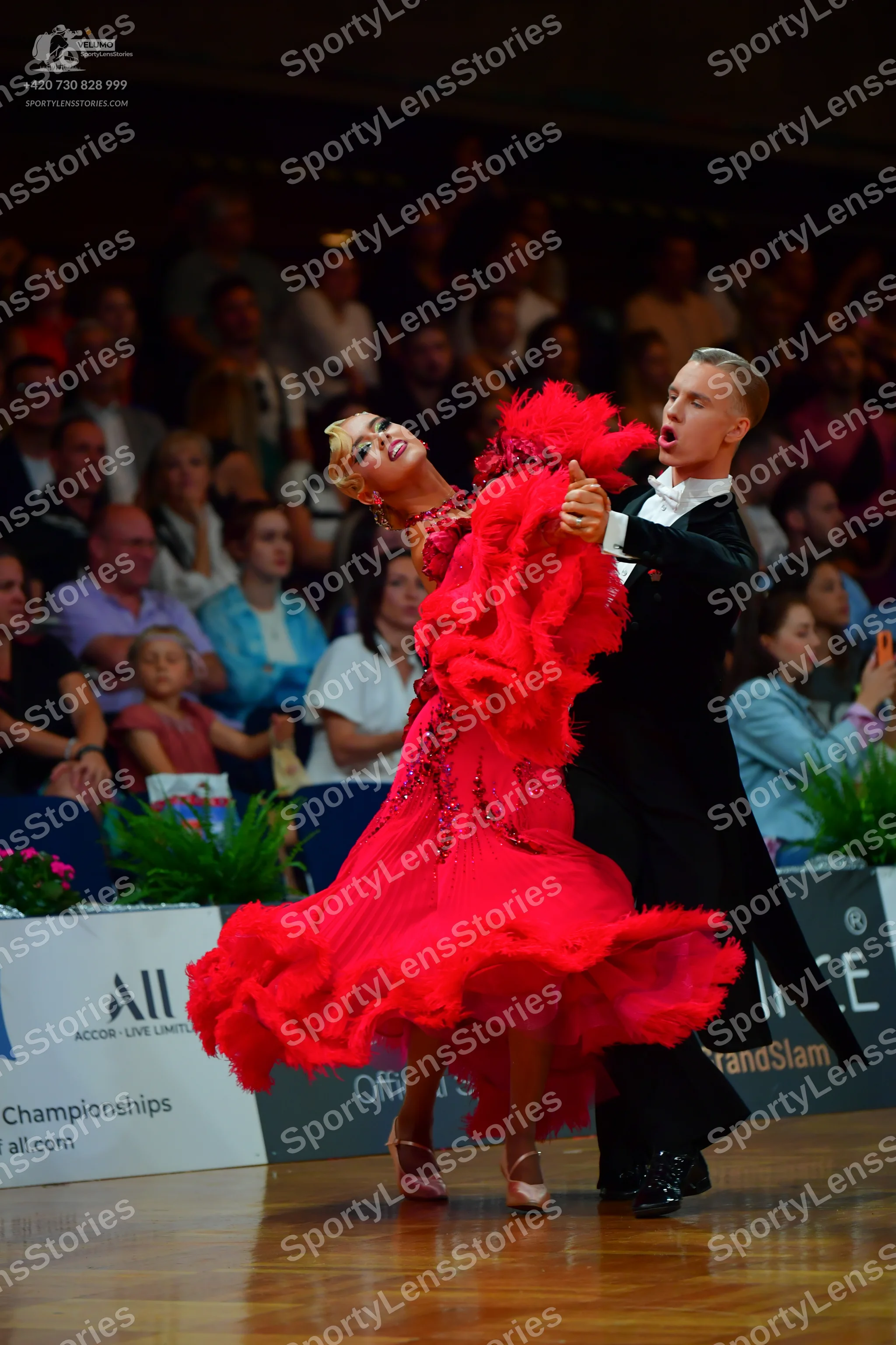 Dancesport competitor: Female dancer: voluminous red ballroom dress with many layers of ruffled, flowin