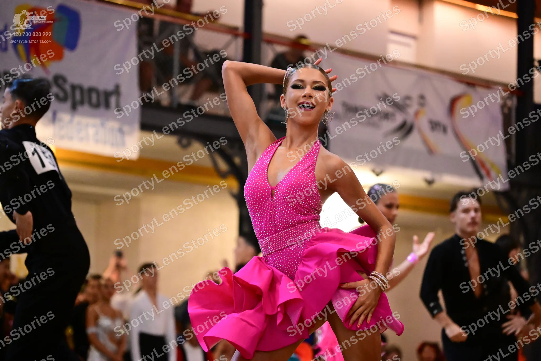 Dancesport competitor #15: Female dancer: pink Latin dress with a halter neck, sequined fabric, and a large