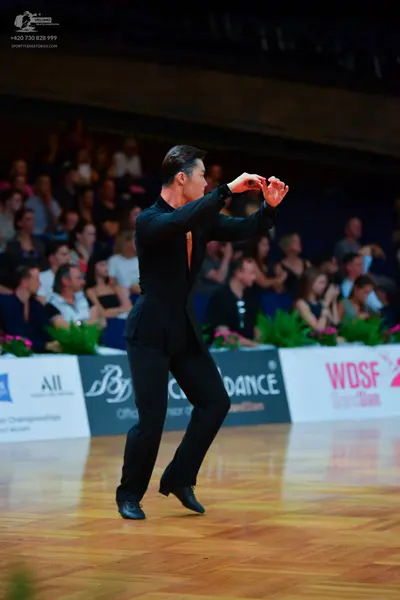 Dancesport competitor: Male dancer: black long-sleeved shirt and black trousers