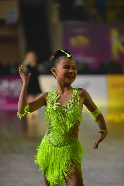 Dancesport competitor: Female dancer: lime green latin dress with fringe and sequins, with matching arm