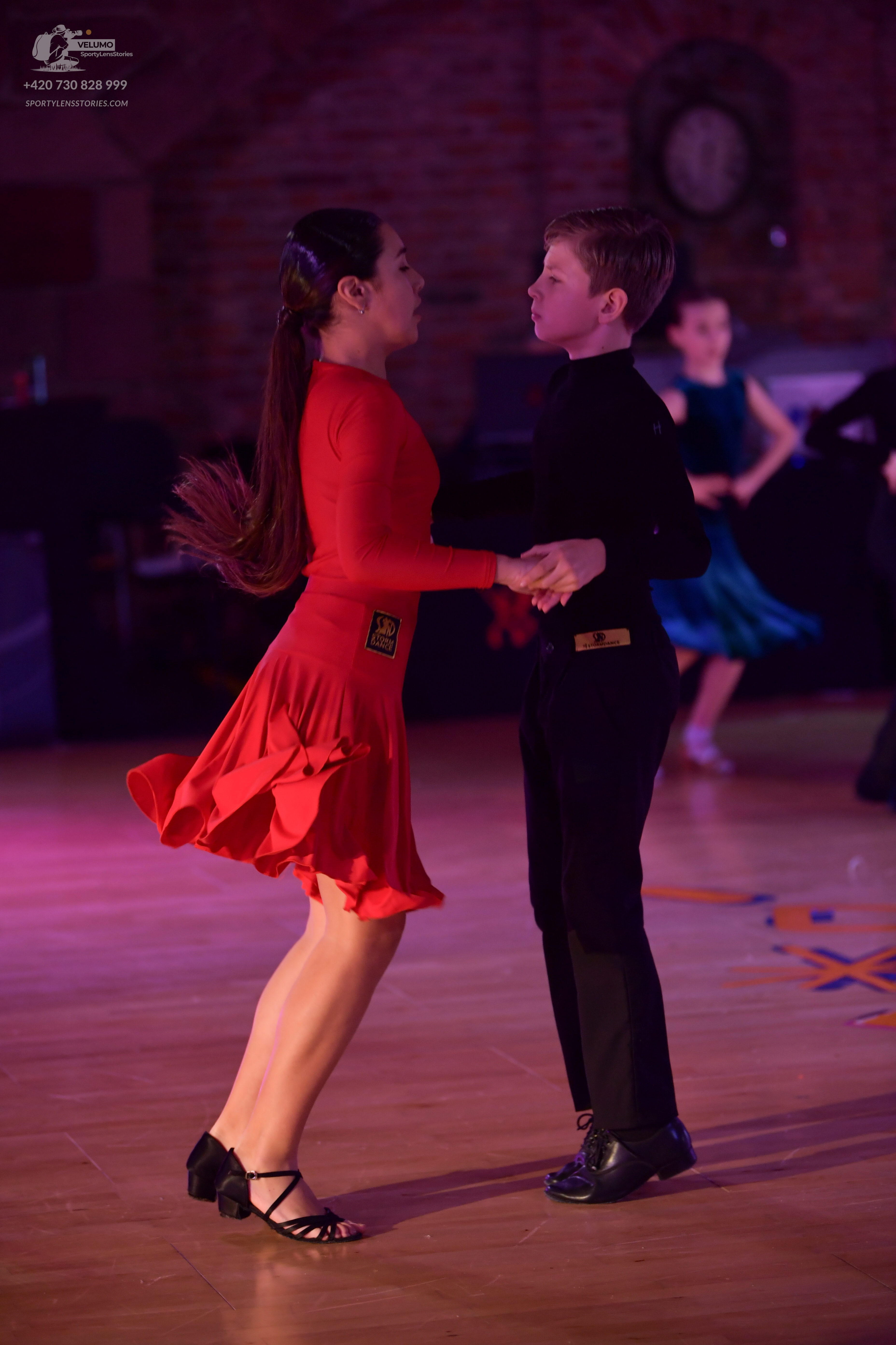 Dancesport competitor: Female dancer: red long-sleeved Latin dress with a flared skirt