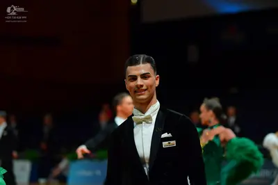 Dancesport competitor: Male dancer: black suit with a white shirt and white bow tie