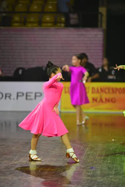 Dancesport competitor: Female dancer: pink long-sleeved dress with a flared skirt