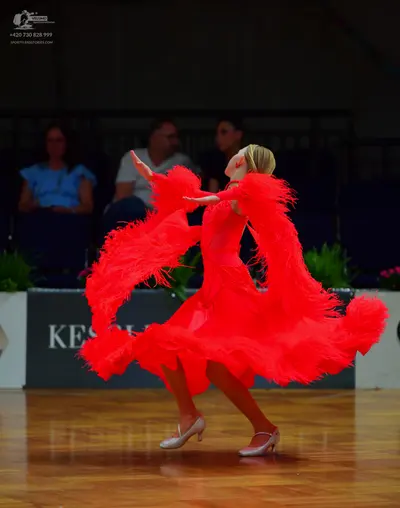 Dancesport competitor: Female dancer: bright red Latin dance dress with voluminous red feather or fring