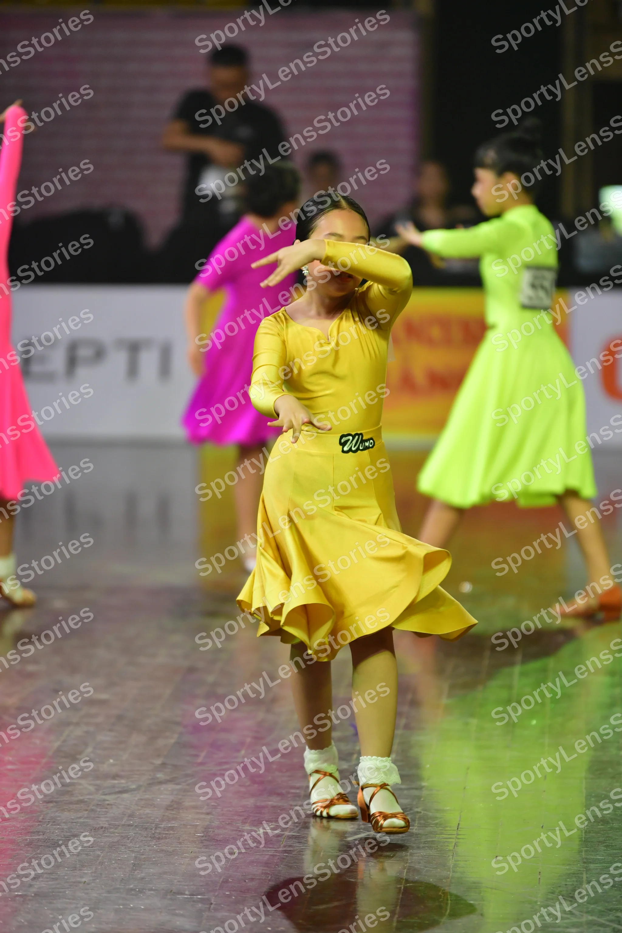 Dancesport competitor #26, #21: Female dancer: yellow latin dress with long sleeves and a flared skirt