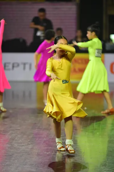 Dancesport competitor #26, #21: Female dancer: yellow latin dress with long sleeves and a flared skirt