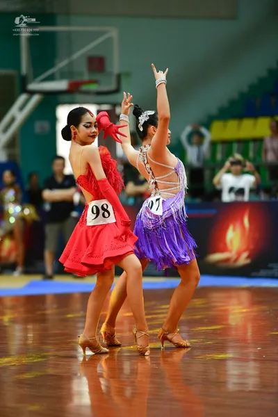 Dancesport competitor #98: ** Red Latin dress
*   **Fabric:** Satin (likely with a slight sheen)
*   **Styl