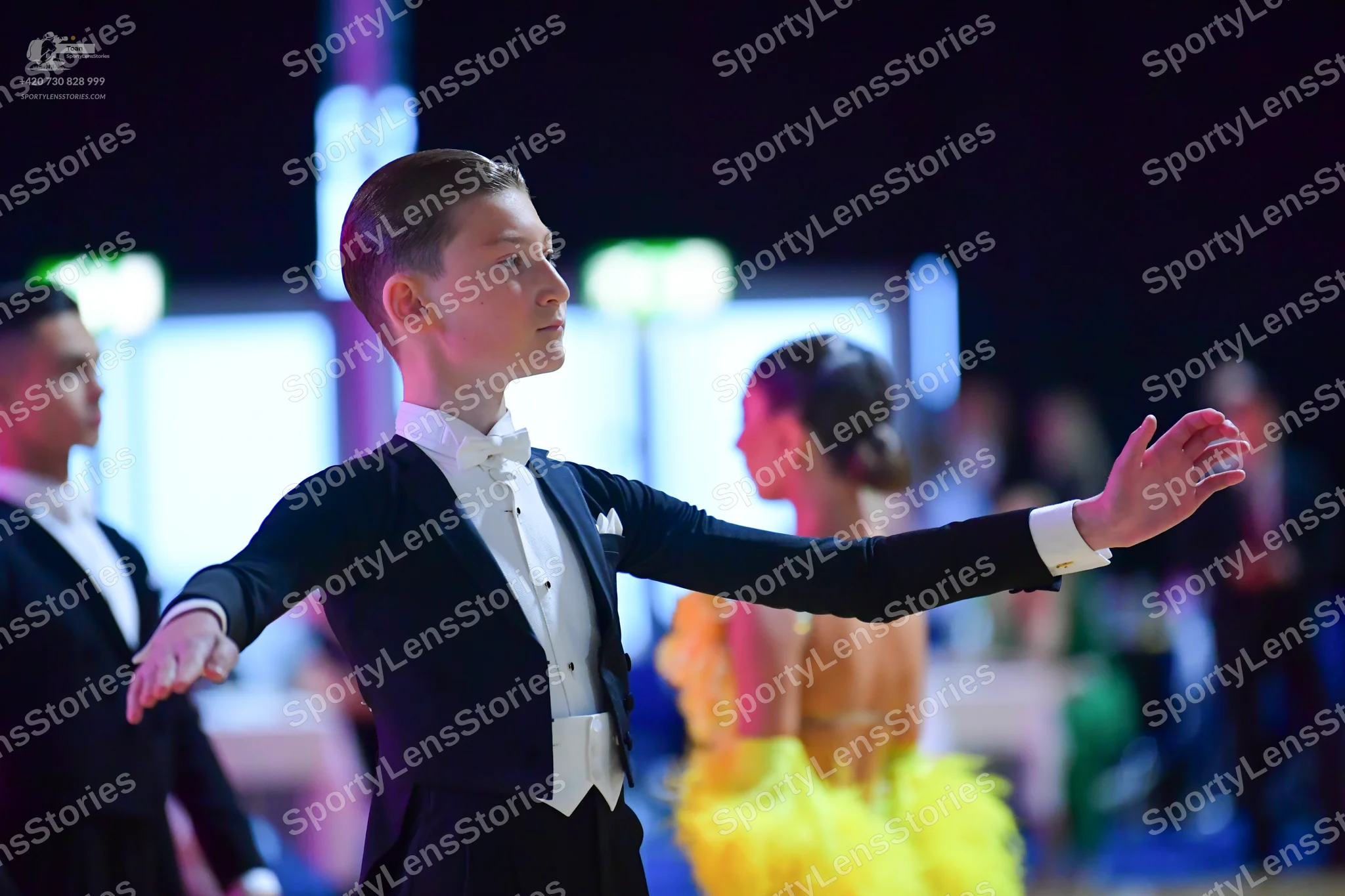 Dancesport competitor: Male dancer: black suit with white shirt, white bow tie, and white waistcoat